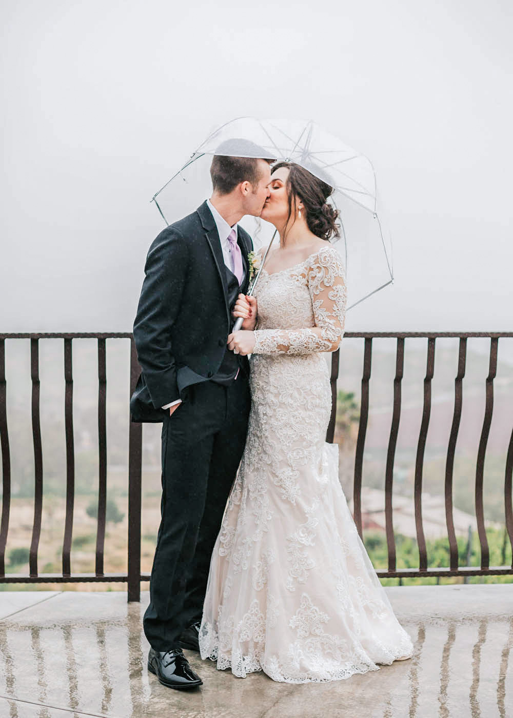 Ciara and Alec share a kiss in the rain during their san diego micro wedding.